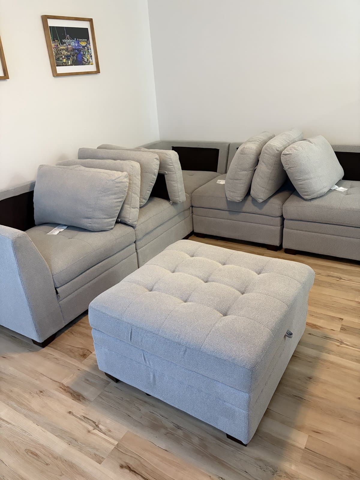 Freshly cleaned grey modular fabric sofa and matching ottoman in a bright living room